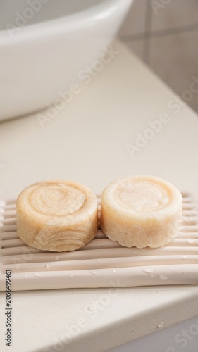 Shampoo bars on bathroom tray with water droplets