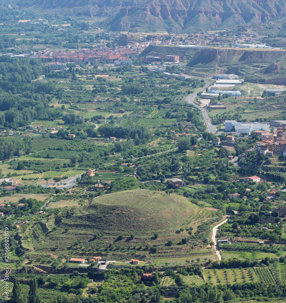 Fototapeta premium Town and Green Valley Below Eroded Hills in La Rioja