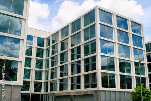 This is a big, modern office building with reflections of old buildings on the opposite site.