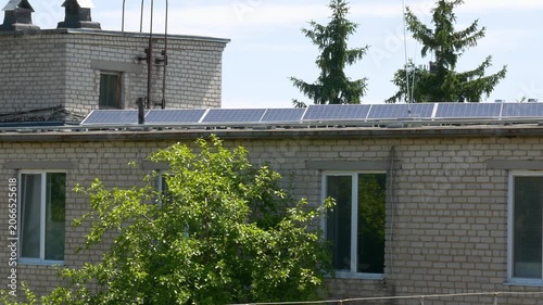 The Concept of Green Energy in an Urban Environment. Solar panels on the roofs of old apartment buildings. A rooftop solar power plant.