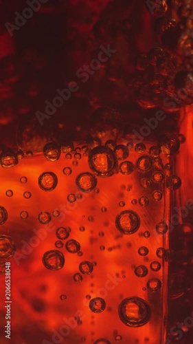 Close-up of bubbles in a glass with ice, slow motion