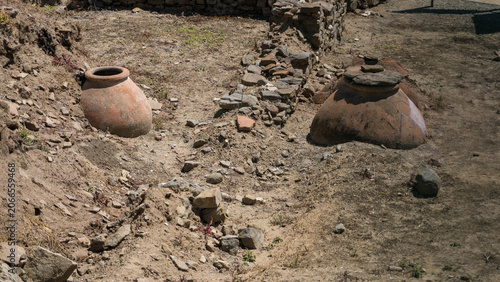 Bild auf Leinwand Ancient red clay amphorae pots partially buried in the ground at an archaeologic