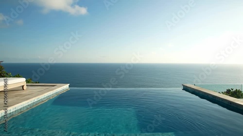 Luxury Infinity Pool Overlooking The Vast Blue Ocean At A Tropical Resort.