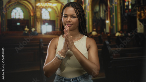 Canvas Print Woman singing with hands gesturing inside a church building, eyes closed and expressive face while standing at a pew; devotion