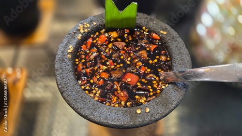 Traditional Indonesian sweet soy chili sauce served in a stone bowl. Rich blend of chilies, spices, and seasonings ideal as a dipping sauce or condiment