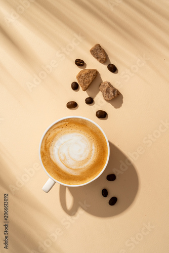 Coffee cup cappuccino foam at colored background with hard shadow.