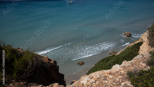 Aerial View of a Secluded Beach with Turquoise Water and a Sailboat