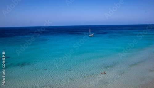 Sailboat Anchored in Turquoise Blue Ocean Water with People Swimming