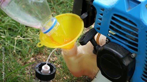 Close Up of Refueling a Gasoline String Trimmer Before Grass Cutting