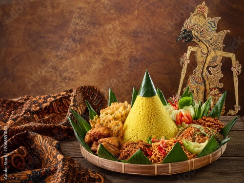Nasi tumpeng with batik and wayang puppet Indonesian tradition