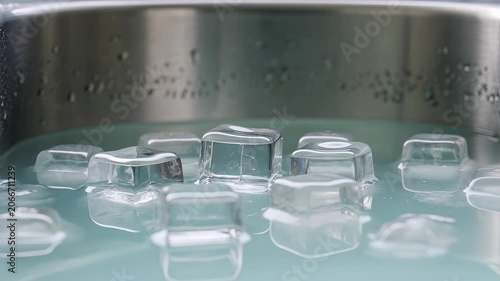 Ice cubes floating in water inside a metal tub for a cold plunge. 4K Video