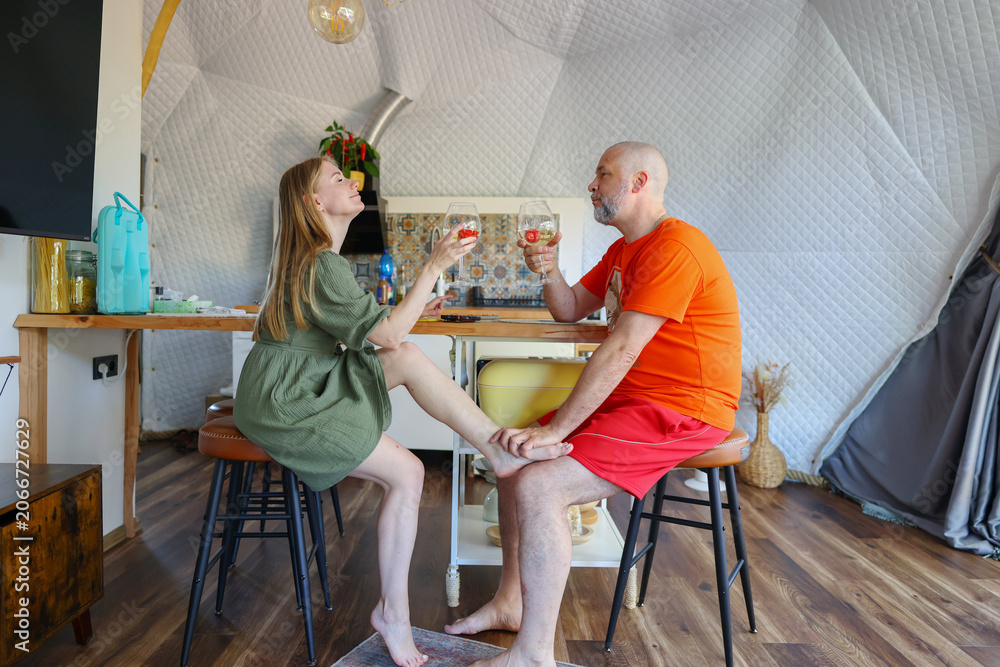 Fototapeta premium Romantic evening in a modern geodesic dome with a couple toasting wine during a cozy vacation retreat.