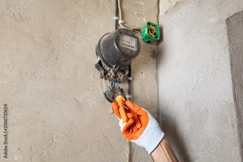 Foto Man working an electricity meter. Counting kilowatt
