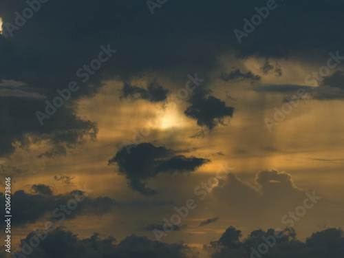 Cuadro en lienzo Dark thick clouds that partially obscure the bright sun twilight rays sunlight penetrating through clouds stormy weather or afternoon skies
