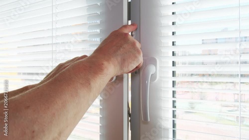 Close-up of a white window sash mounted on an opening position limiter