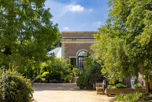 Historic Herbgarden (Kruidtuin) in Leuven, Belgium with greenhouse entrance and lush potted plants