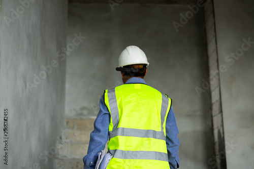 Cuadro en lienzo Construction engineer walking upstairs inside an unfinished building during site inspection