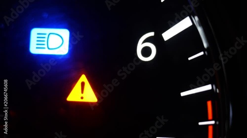 Car dashboard master warning light and high beam indicator close up