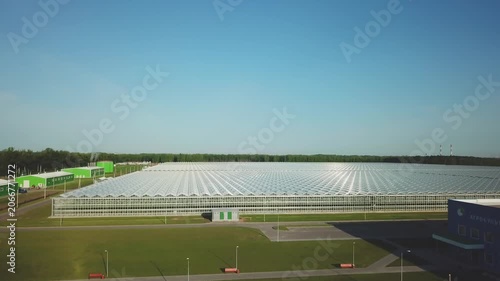 Drone ascending over large greenhouse complex