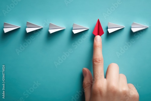 Creative Paper Art with Red Paper Arrow and Hand Touching on Blue Background