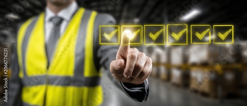 Businessman in high visibility vest checking safety checklist in warehouse