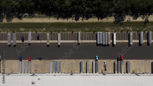 Aerial top down view of a large logistics distribution warehouse center with cargo trailers parked at loading docks