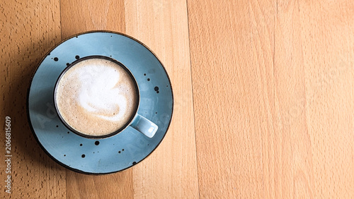 top view of coffee cup with latte art on wooden table