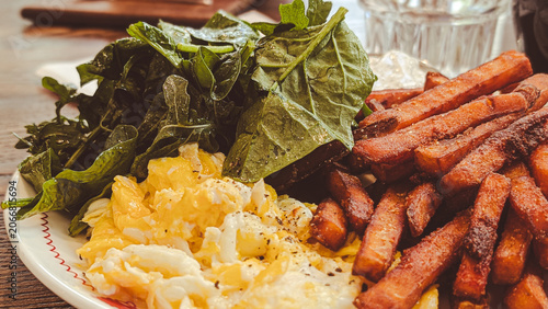 close up of breakfast plate with scrambled eggs and sweet potato fries