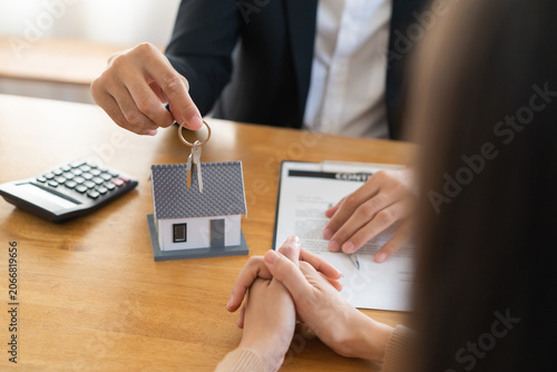 Close up agent giving a key to new owner or tenant, client after signed signature contract rental purchase, buyer apartment, home with landlord, realtor. Banker agreement mortgage loan. Property lease
