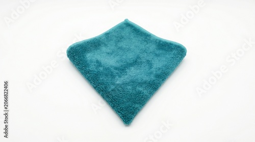 Folded teal microfiber cleaning cloth on white surface