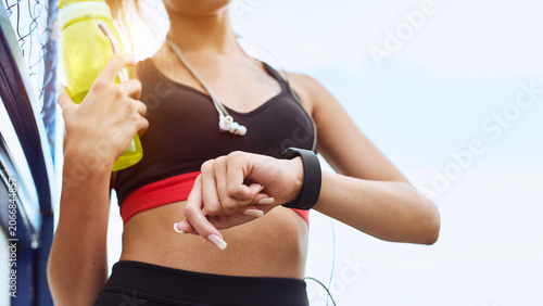 Tableau sur toile Young sportswoman with smart watch training outdoor