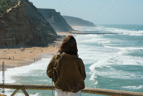Woman Looking at Cliff-Lined Beach and Ocean from Viewpoint, Portugal