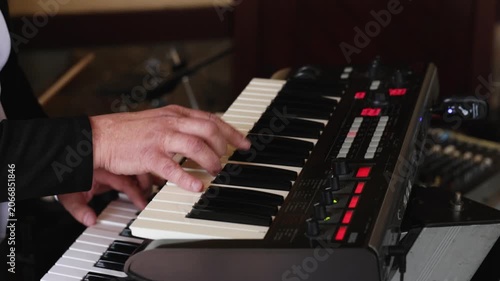 Male hands playing on piano electronic keyboard. The musician playing the electric piano, Electric piano. Actor playing on the keyboard synthesizer piano keys