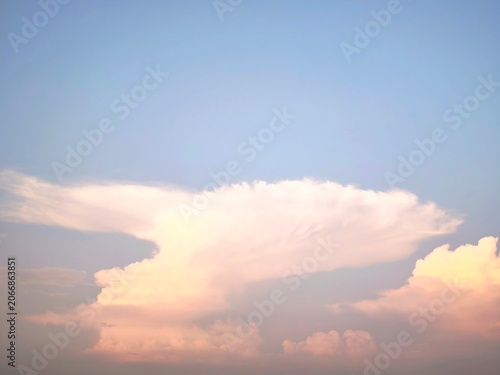 Konstfotografi Towering cumulonimbus clouds illuminated by sunset hues beneath expansive blue sky