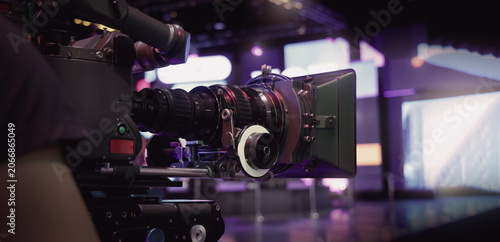Foto Behind the scenes of movie shooting or video production at studio with high quality camera gimbal or tripod equipment set up and professional film crew team or camera operator with flare lighting