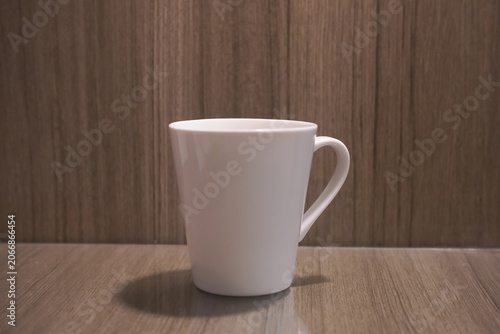 Ideal for branding mockups, this minimalistic mug on a wooden surface can be used for product presentations and coffee shop designs.