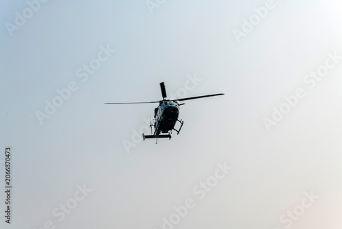 Silhouette Military helicopter flying on isolated blue sky