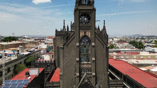 Drone ascending video capturing the majestic Our Lady of the Rosary Parish and Father Galvan Temple in Guadalajara, Mexico, under a clear blue sky.