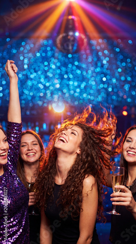 Joyful young women celebrating a friend forthcoming marriage at a lively indoor hen party event.