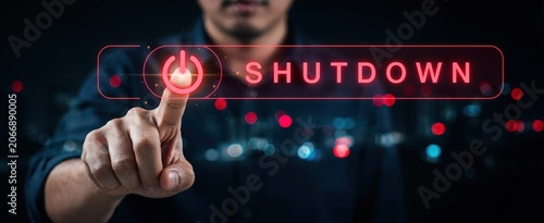 Businessman hand pressing a virtual power off button for concept of digital shutdown and system management.