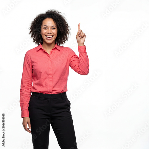 Woman pointing upward with excited expression in professional outfit against white background for business innovation concept