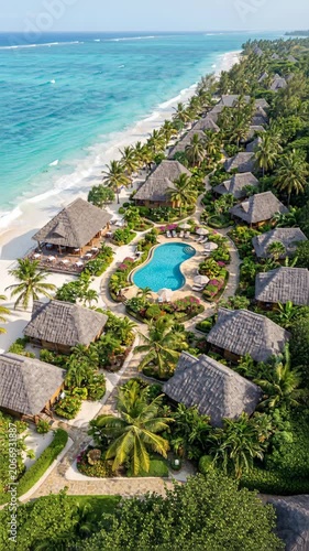 Aerial view of a tropical beach resort with thatch roof bungalows