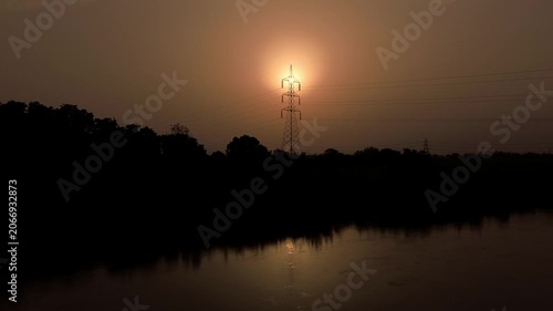 sun set through electric  tower 
