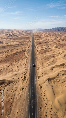Aerial view of a long straight road through a vast desert landscape