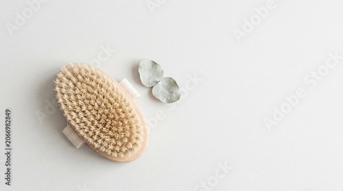 Natural body brush with smooth stones on white background  
