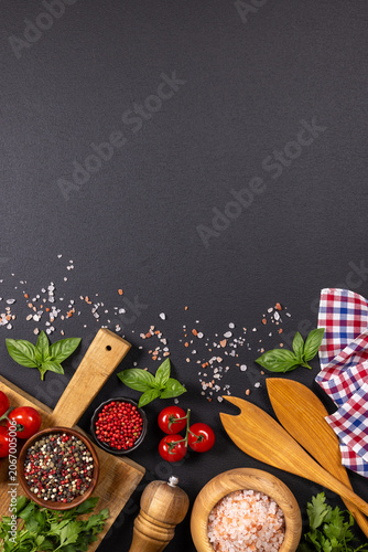 Fresh cooking ingredients and spices on dark background
