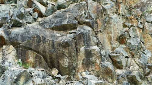 Fotografie A dramatic, dark-toned close-up of a granite rock face, perfect for textured backgrounds requiring a sense of geological depth and ruggedness
