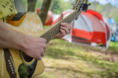 Playing Acoustic Guitar at Summer Campsite Outdoors