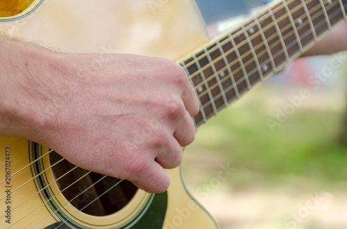 Close Up of Acoustic Guitar Player Outdoors