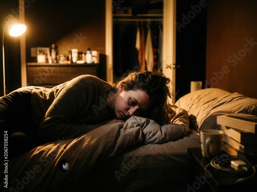 Young Woman Resting Alone In Dimly Lit Bedroom At Night